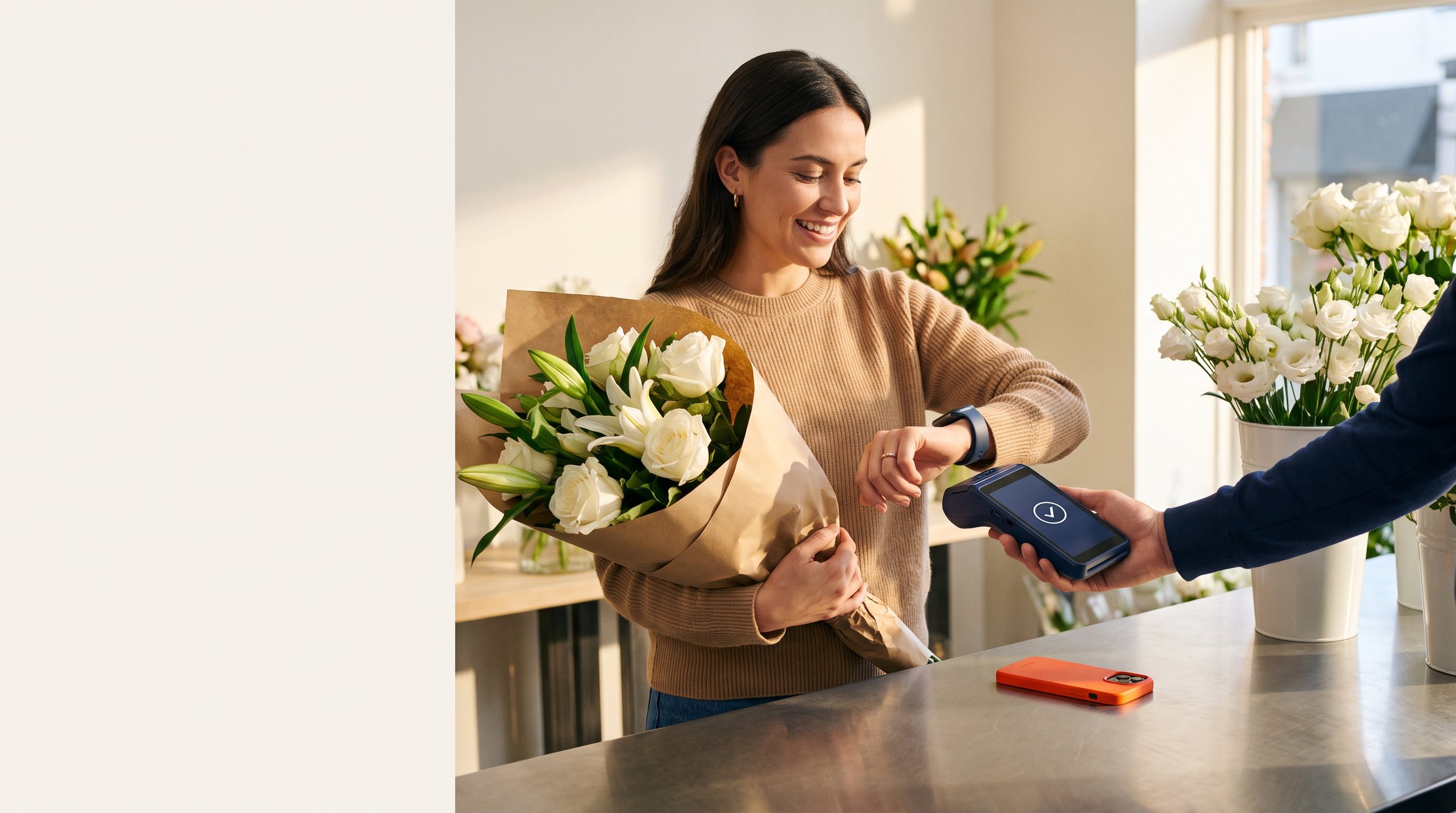 A smiling customer holding a kraft-wrapped bouquet pays with her smartwatch on a handheld card terminal at a flower shop counter.